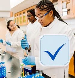 students working in a lab wearing labcoats and glasses